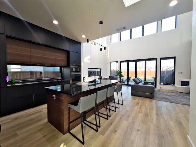 kitchen featuring visible vents, modern cabinets, dark countertops, and a kitchen bar