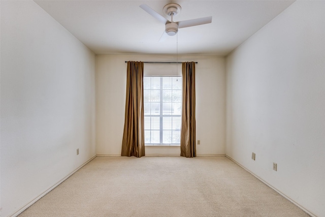 spare room with ceiling fan and light carpet