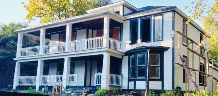 back of property featuring a balcony and a porch