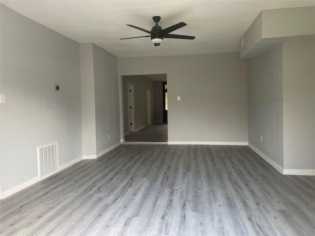 spare room with visible vents, baseboards, ceiling fan, and wood finished floors