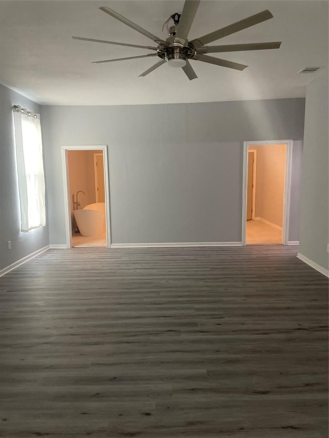 empty room with visible vents, baseboards, wood finished floors, and a ceiling fan