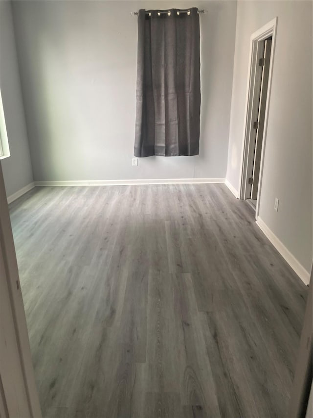 unfurnished room with wood finished floors and baseboards