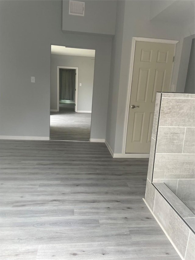 unfurnished room with visible vents, baseboards, and wood finished floors