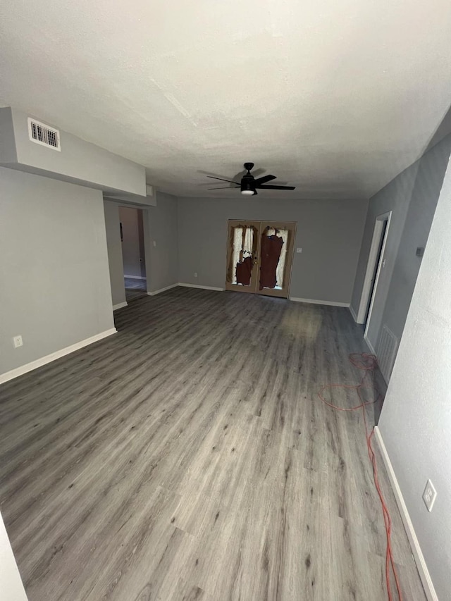 unfurnished living room featuring ceiling fan, wood-type flooring, and a textured ceiling