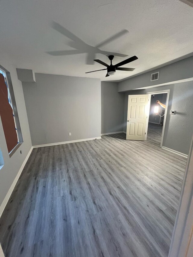 unfurnished bedroom featuring wood-type flooring, ceiling fan, and a textured ceiling