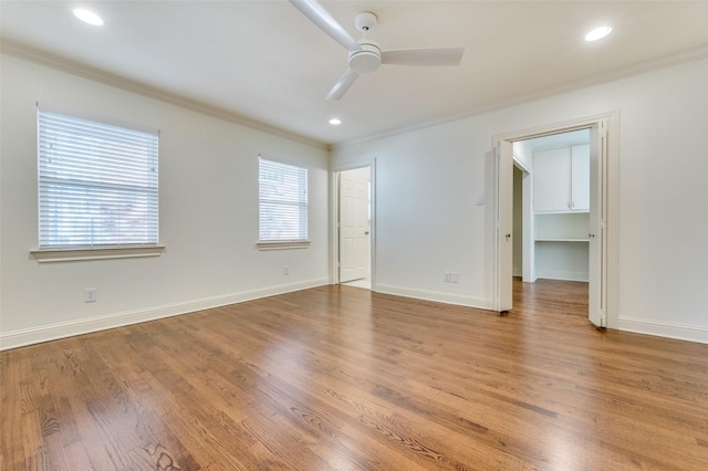 empty room with ornamental molding, wood-type flooring, and ceiling fan