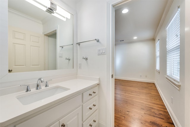 bathroom featuring ornamental molding, wood-type flooring, and vanity