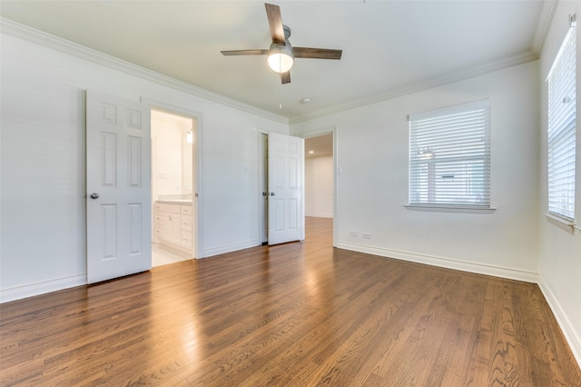 unfurnished bedroom with ornamental molding, dark wood-type flooring, connected bathroom, and ceiling fan