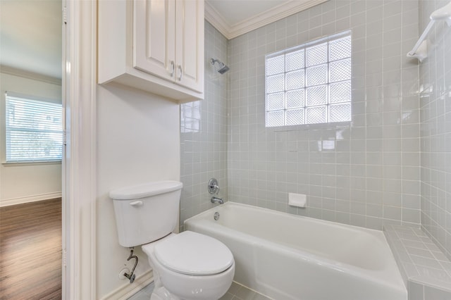 bathroom featuring crown molding, wood-type flooring, tiled shower / bath combo, and toilet