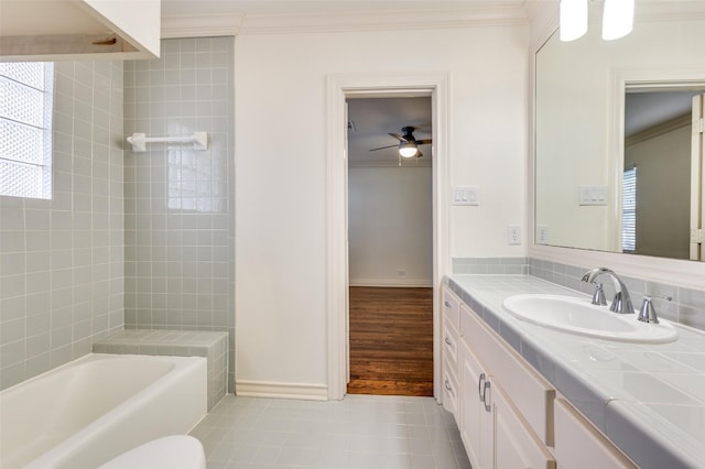 bathroom with tile patterned flooring, crown molding, a tub, and vanity