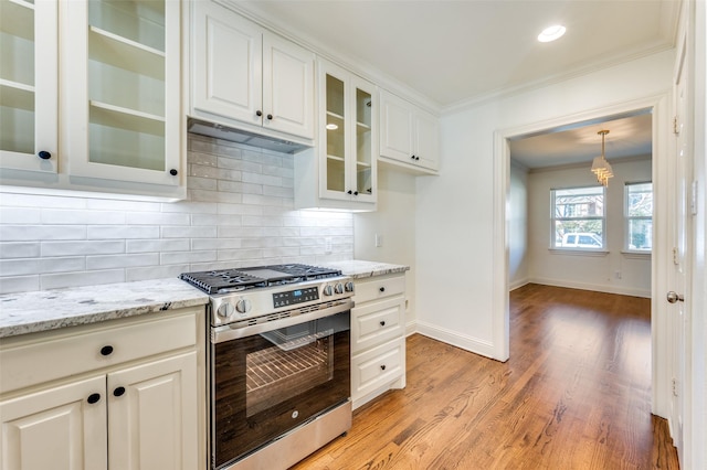 kitchen featuring white cabinetry, stainless steel range with gas cooktop, crown molding, and pendant lighting