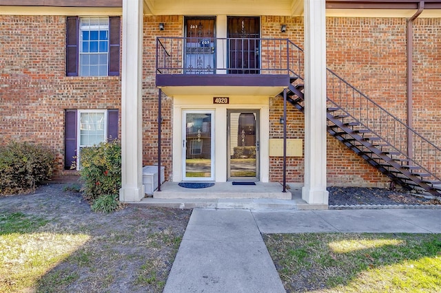 doorway to property featuring brick siding and a balcony