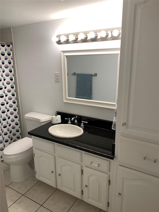 full bathroom featuring toilet, curtained shower, tile patterned flooring, and vanity