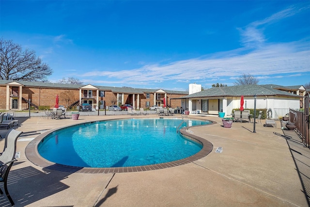 pool featuring a patio area, a residential view, and fence