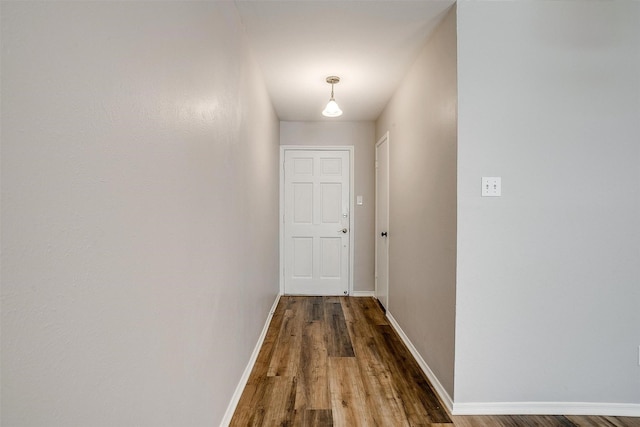 hallway with baseboards and wood finished floors