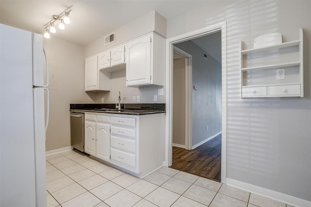 kitchen featuring light tile patterned floors, visible vents, white cabinetry, freestanding refrigerator, and dishwasher