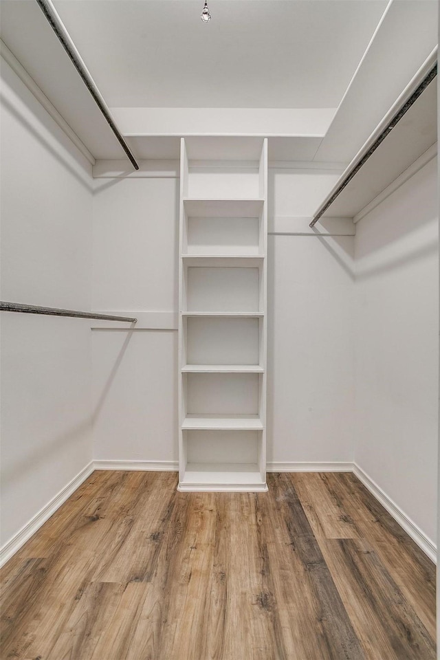 walk in closet with wood finished floors