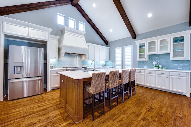 kitchen featuring stainless steel appliances, premium range hood, and white cabinetry