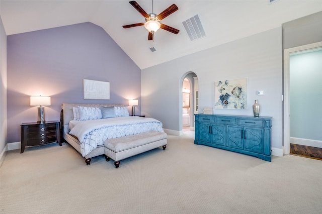 carpeted bedroom with ceiling fan, high vaulted ceiling, and ensuite bath