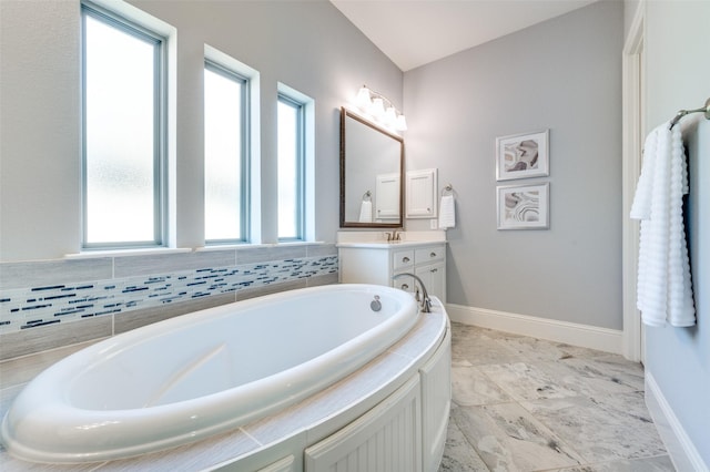 bathroom with tiled tub and vanity