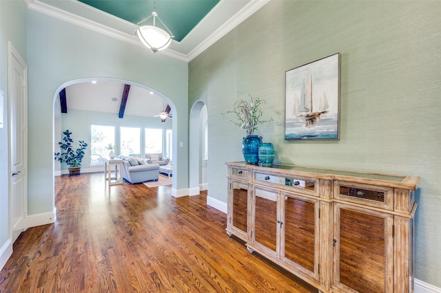 hallway featuring hardwood / wood-style flooring, crown molding, and beam ceiling