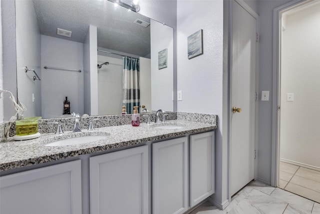 bathroom featuring vanity, curtained shower, and a textured ceiling