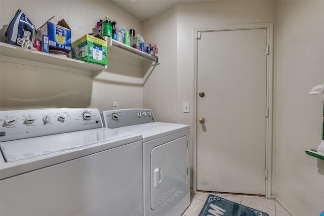 laundry area with washing machine and dryer and light tile patterned flooring