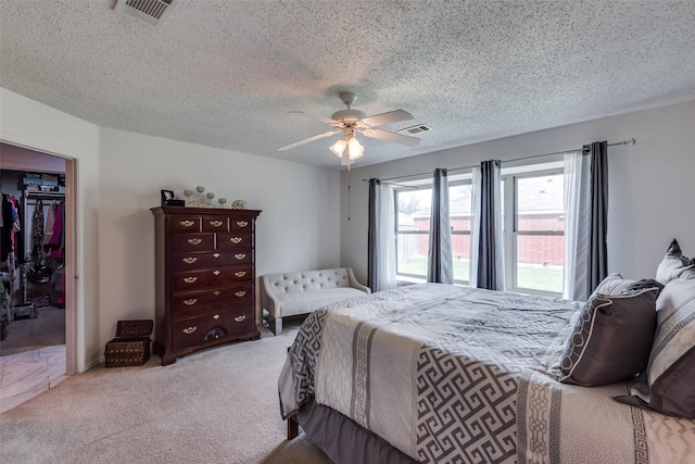 carpeted bedroom with a textured ceiling, a closet, and ceiling fan