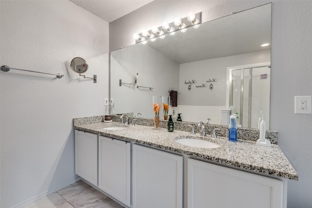 bathroom featuring vanity, an enclosed shower, and a textured ceiling