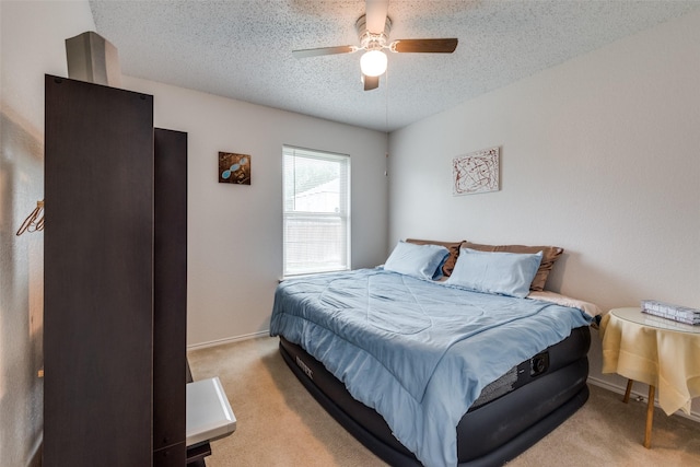 carpeted bedroom featuring ceiling fan and a textured ceiling