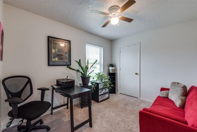 carpeted home office with ceiling fan and a textured ceiling