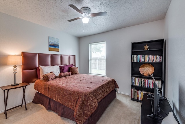 bedroom featuring ceiling fan, light carpet, and a textured ceiling