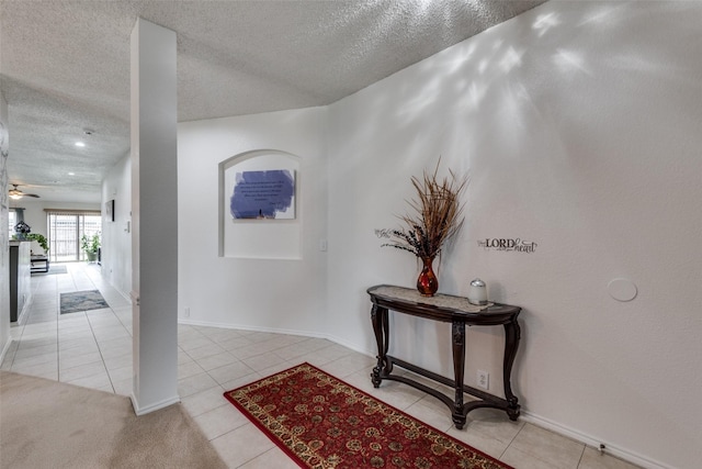 corridor featuring light tile patterned flooring and a textured ceiling