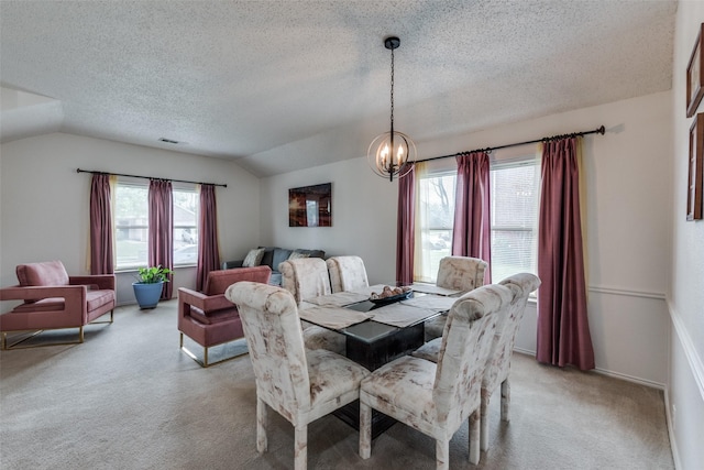 carpeted dining space with vaulted ceiling, a textured ceiling, and a chandelier