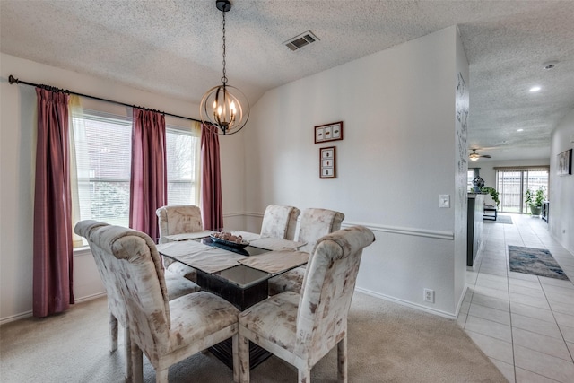 dining area with an inviting chandelier, light carpet, and a textured ceiling