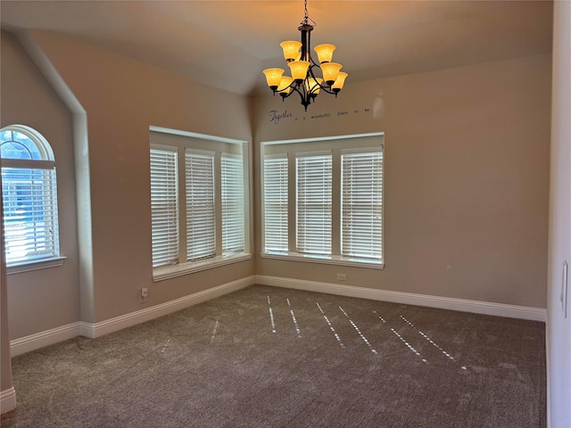 spare room with a notable chandelier and dark carpet