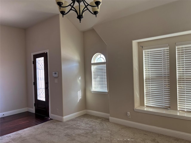 carpeted foyer featuring an inviting chandelier