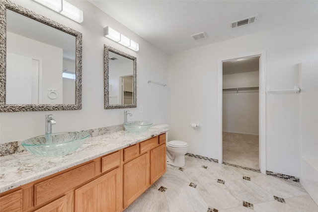 bathroom with vanity, toilet, and a bath