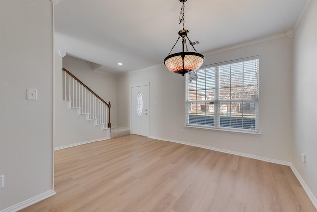 foyer entrance with crown molding and light hardwood / wood-style flooring