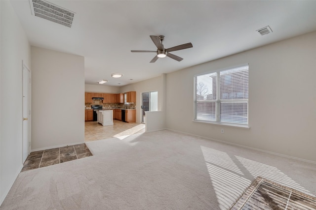 unfurnished living room featuring light colored carpet and ceiling fan