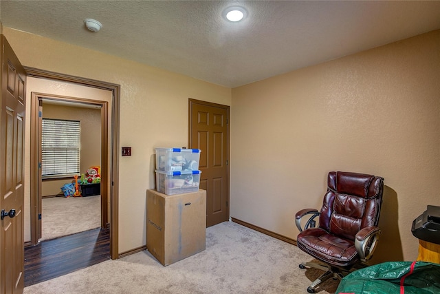 carpeted office with a textured ceiling