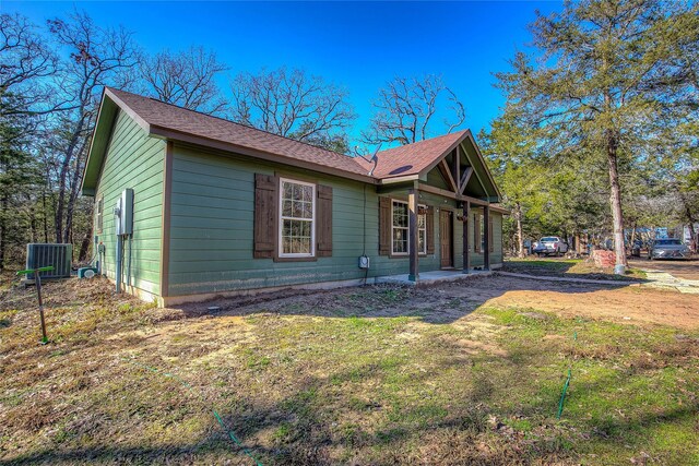 view of property exterior with a yard and central air condition unit