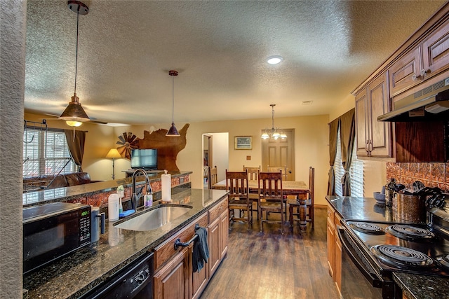 kitchen with dark hardwood / wood-style floors, sink, dark stone countertops, hanging light fixtures, and black appliances