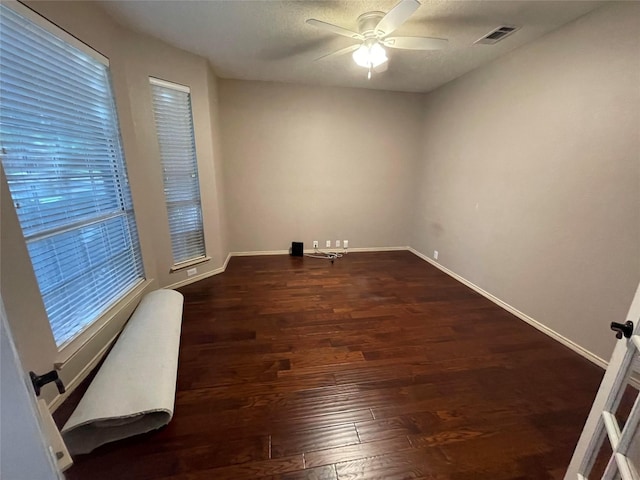 unfurnished room with dark wood-type flooring and ceiling fan