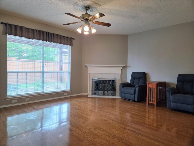 6464 Richmond Dr, Frisco, TX 75035 - unfurnished living room with a tile fireplace, wood finished floors, ceiling fan, a textured ceiling, and baseboards
