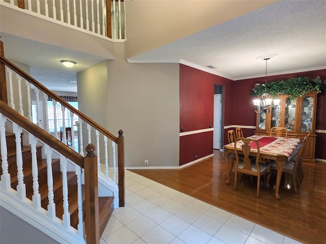 6464 Richmond Dr, Frisco, TX 75035 - tiled dining room with stairs, a chandelier, a textured ceiling, ornamental molding, and baseboards