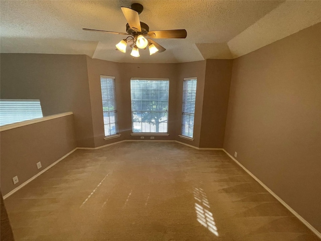 carpeted spare room with ceiling fan and a textured ceiling