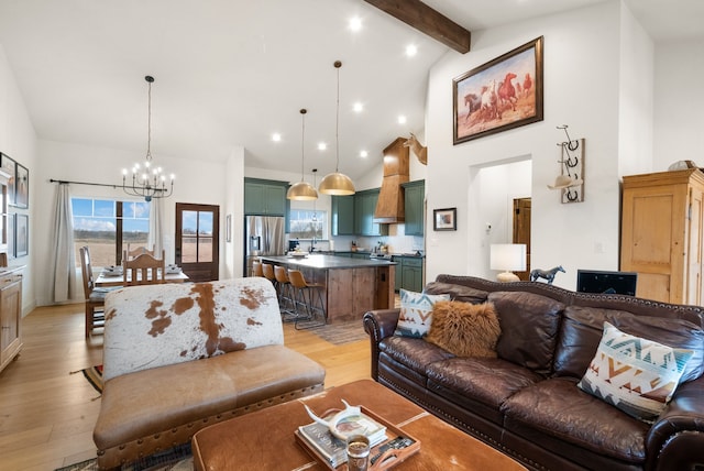 living room featuring beam ceiling, high vaulted ceiling, a notable chandelier, and light hardwood / wood-style floors