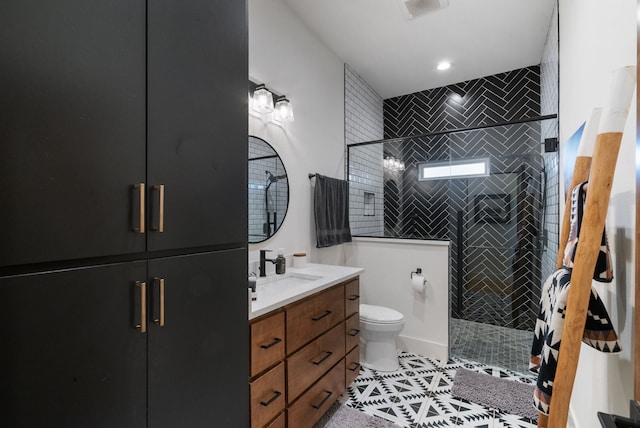 bathroom featuring vanity, toilet, a shower with shower door, and tile patterned flooring