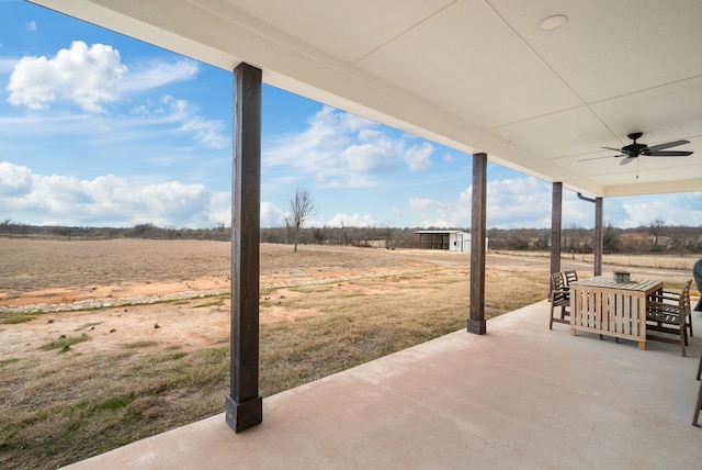 view of patio / terrace featuring ceiling fan and a rural view